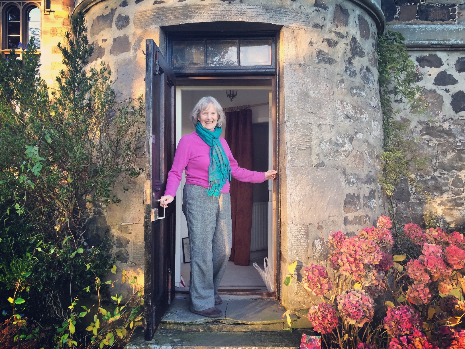 senior-woman-opening-door-to-her-home