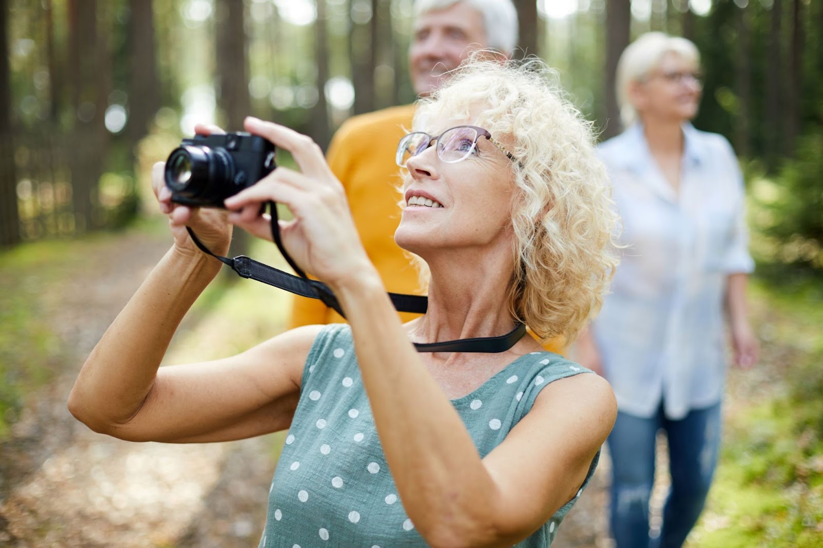 older-walkers-with-camera-in-forest