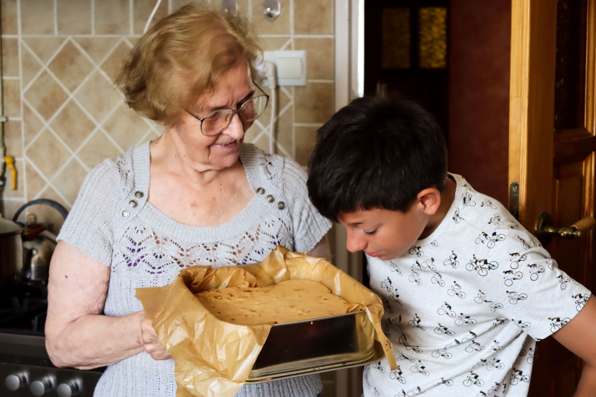 older-woman-bakes-cake-for-young-boy