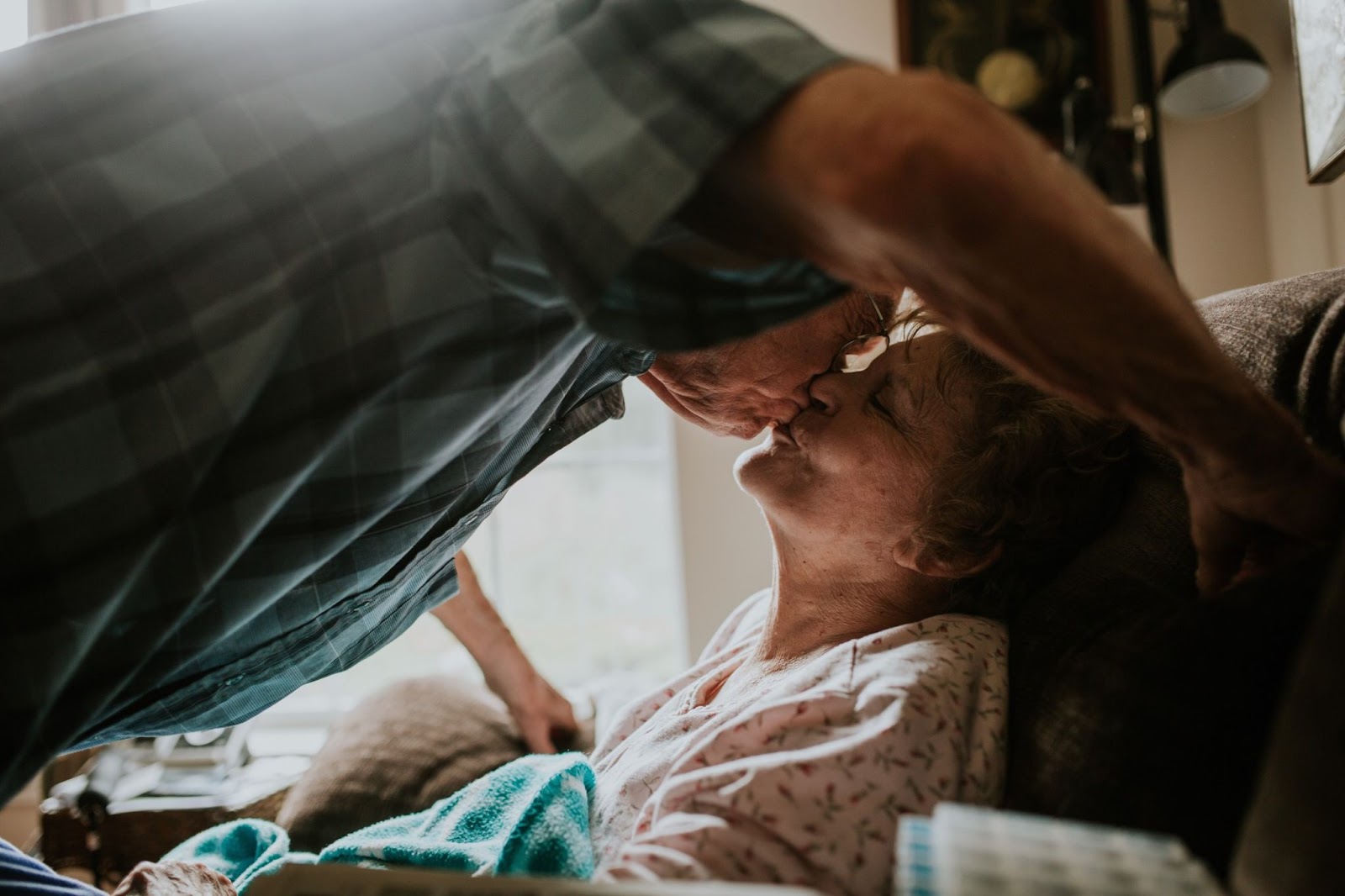 senior-man-kissing-sick-wife-in-chair