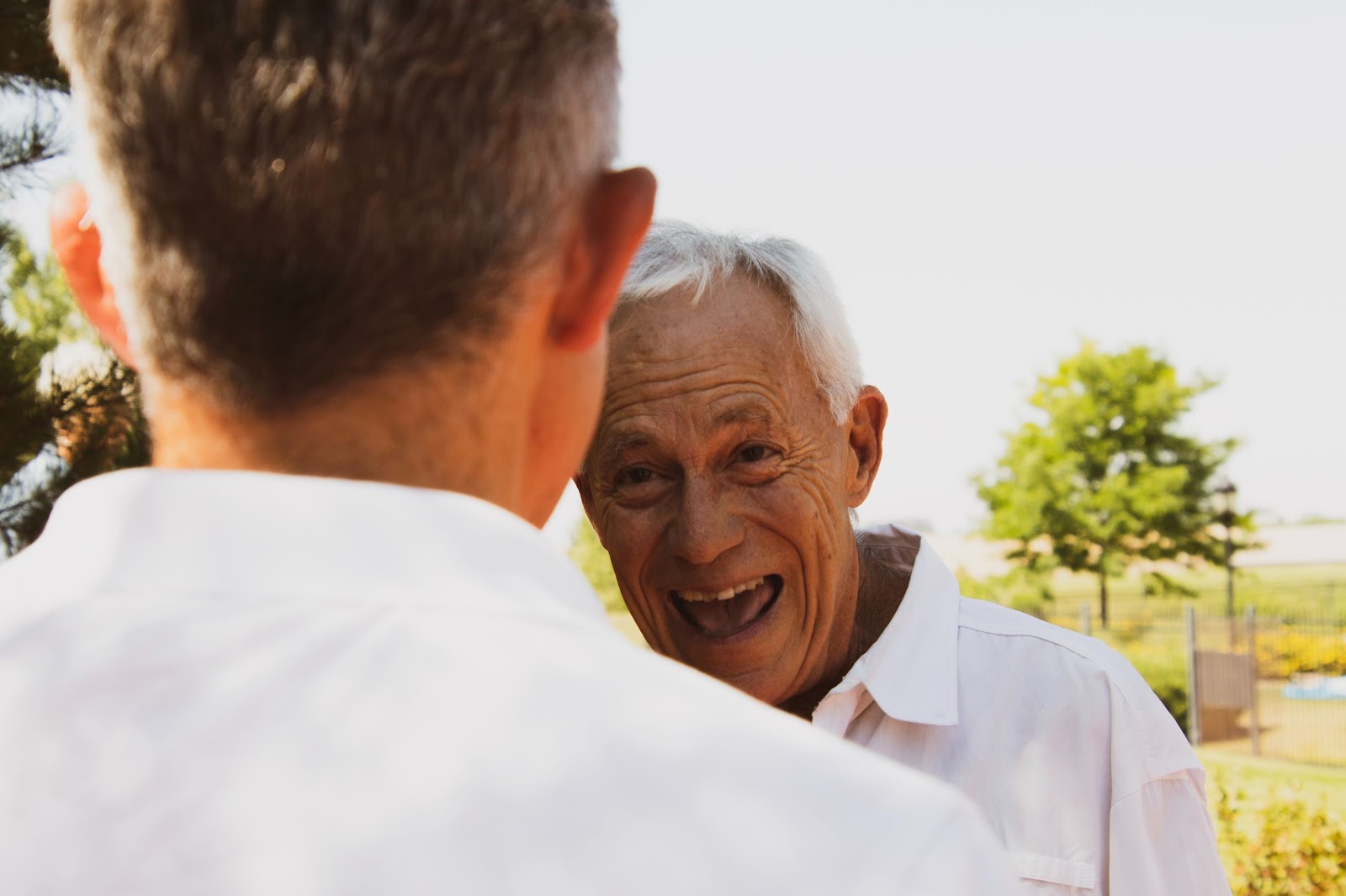 Senior man laughing in conversation with other man