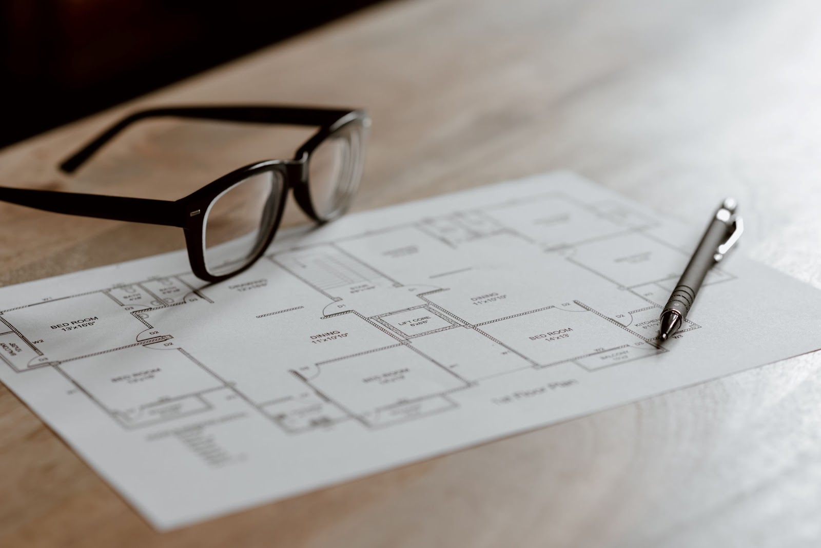 glasses laying on top of house floor plan