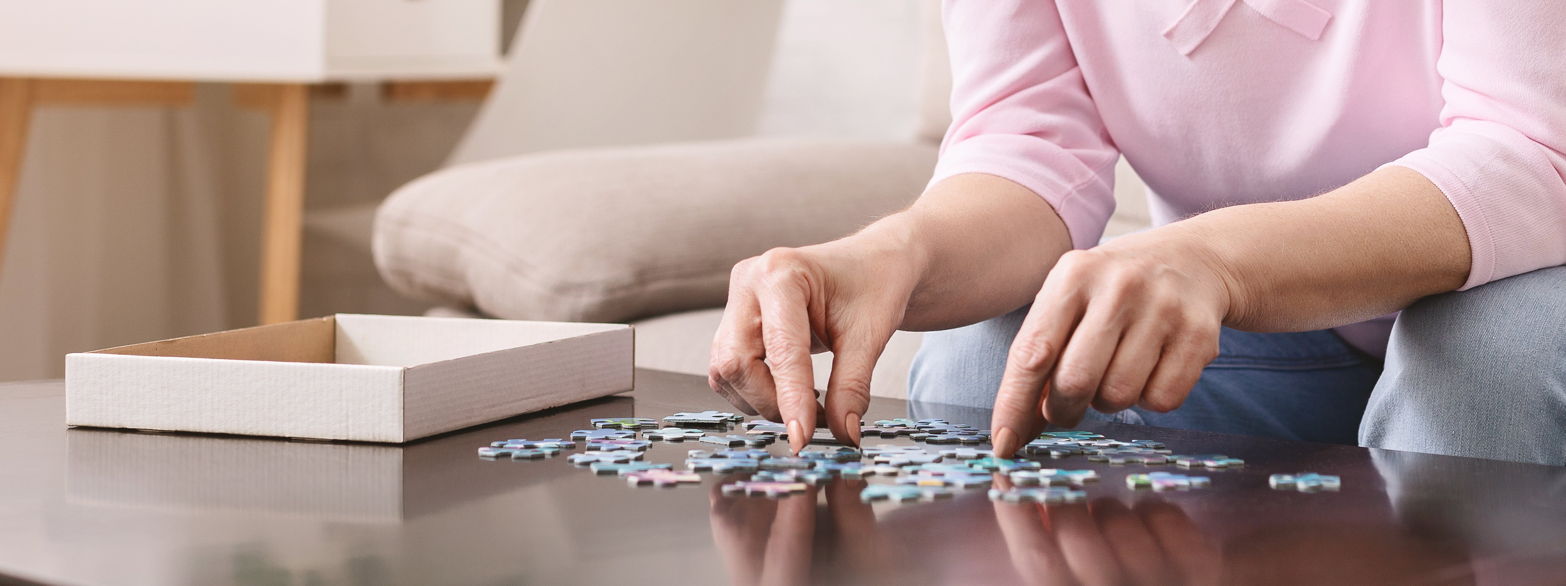 elderly-female-hands-trying-to-connect-pieces-of-puzzle