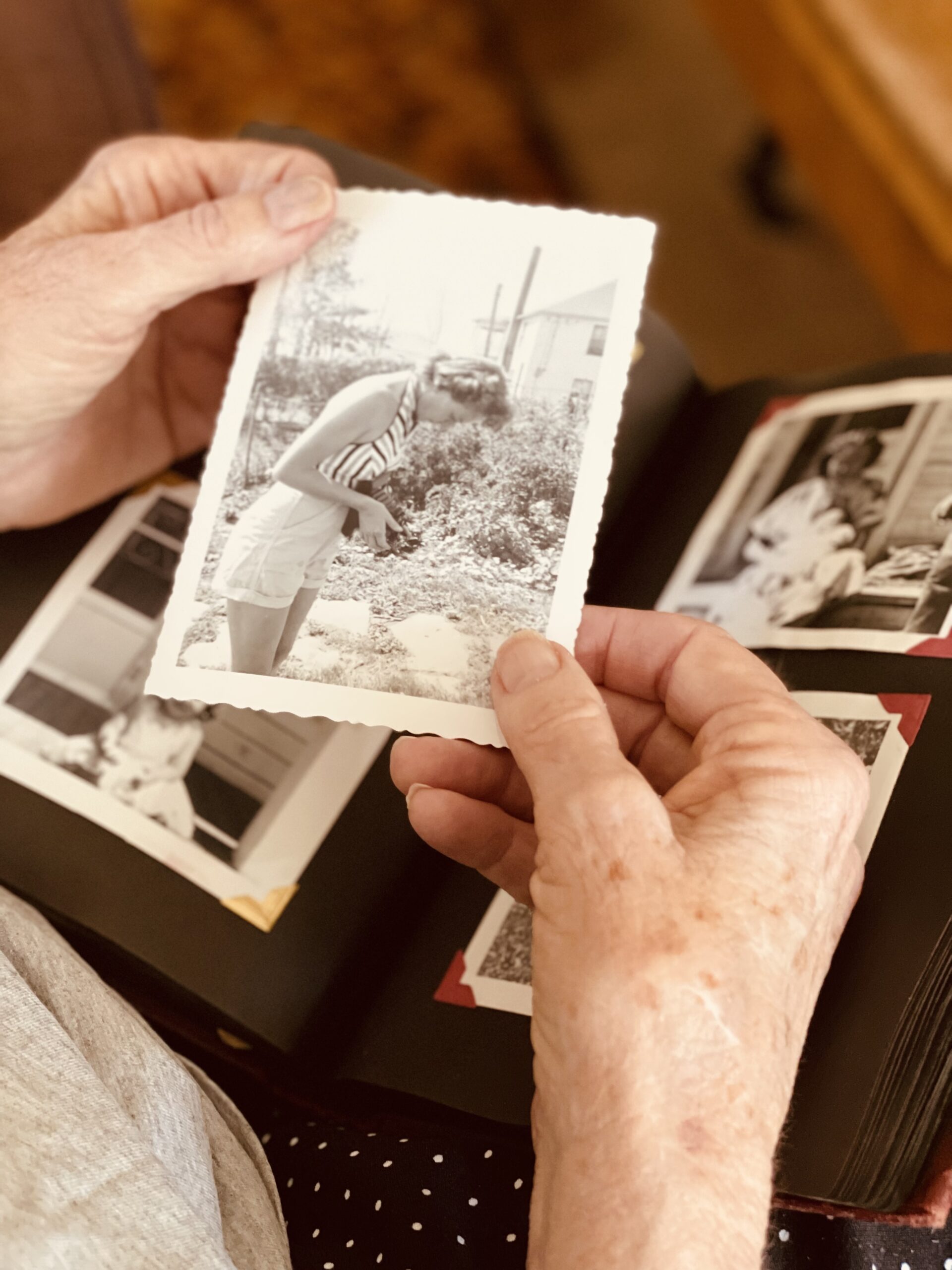 elderly-woman-holding-old-black-and-white-framed-photo-of-her-grandmother-reminiscing-about-family-tree