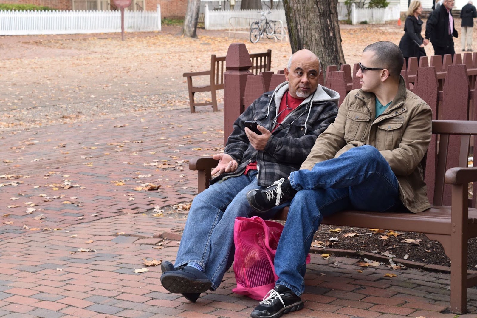 older-man-having-conversation-with-son-in-urban-park