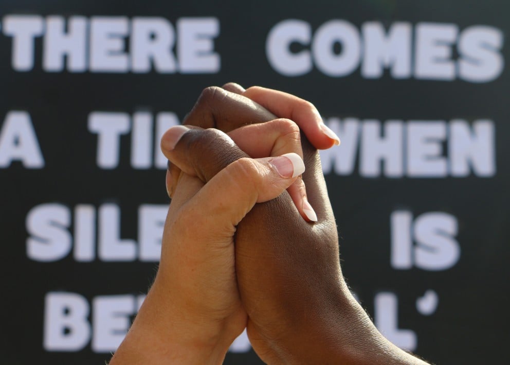 image-of-caucasian-and-african-american-hand-gripped-together-in-foreground-with-black-lives-matter_t20_lL17bg