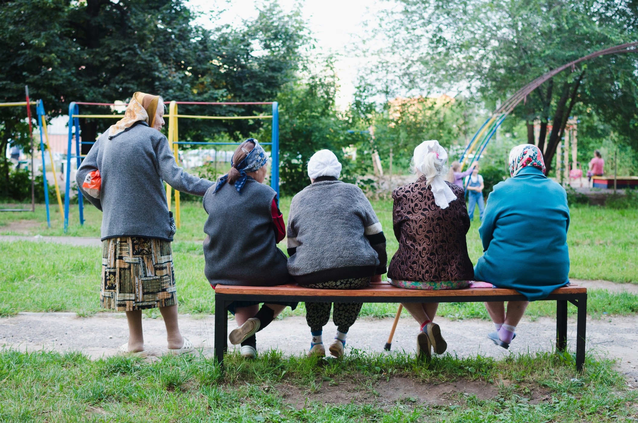 group-of-russian-woman-with-headscarves-sitting-on-bench