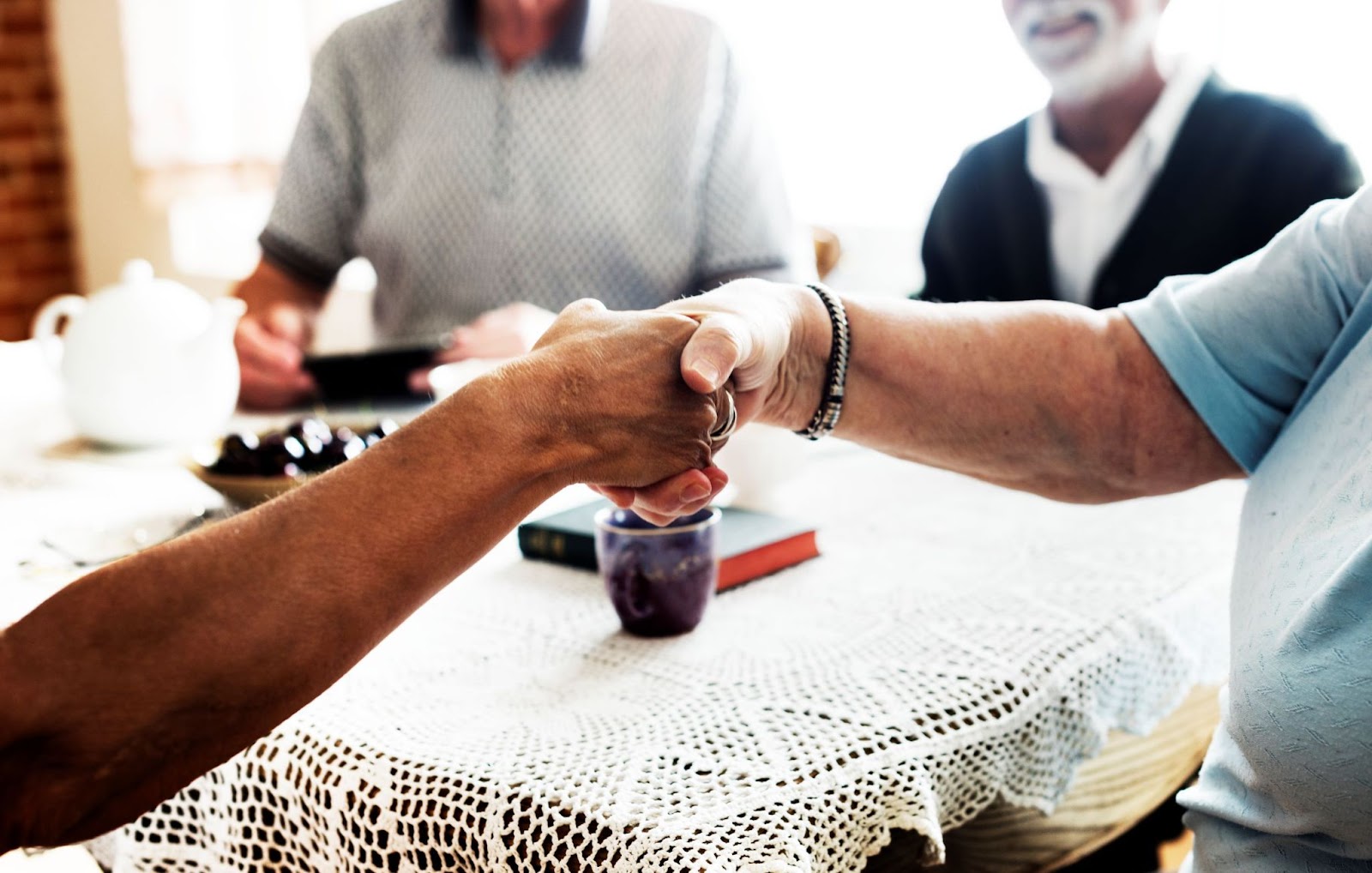 seniors-shaking-hands-across-a-table