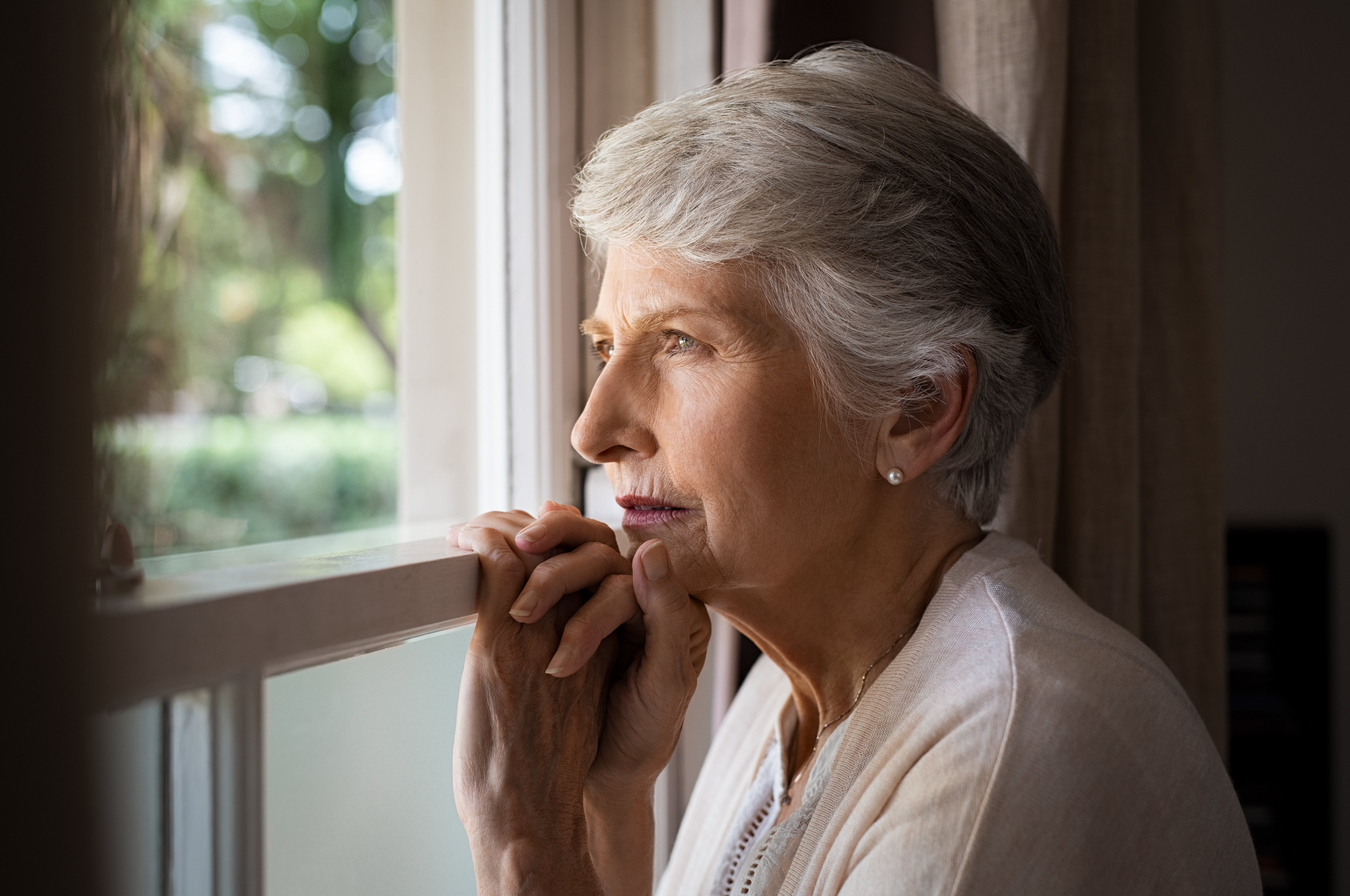 lonely-senior-woman-looking-out-window