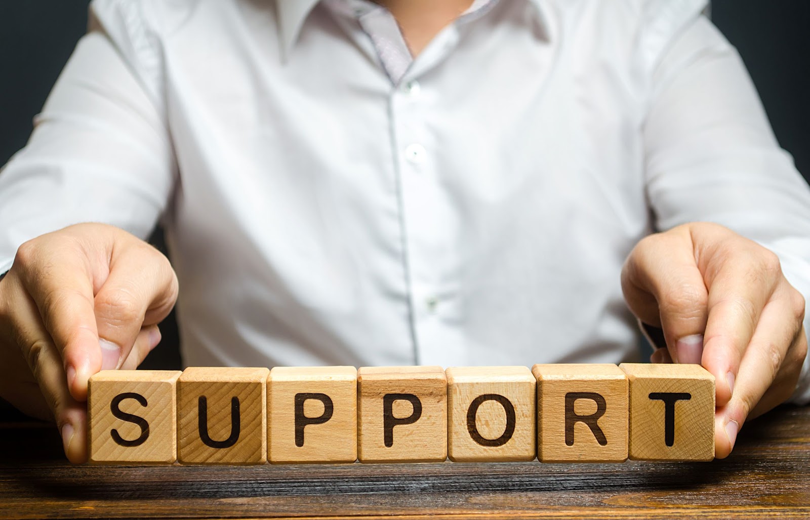 man-holding-blocks-that-spell-support