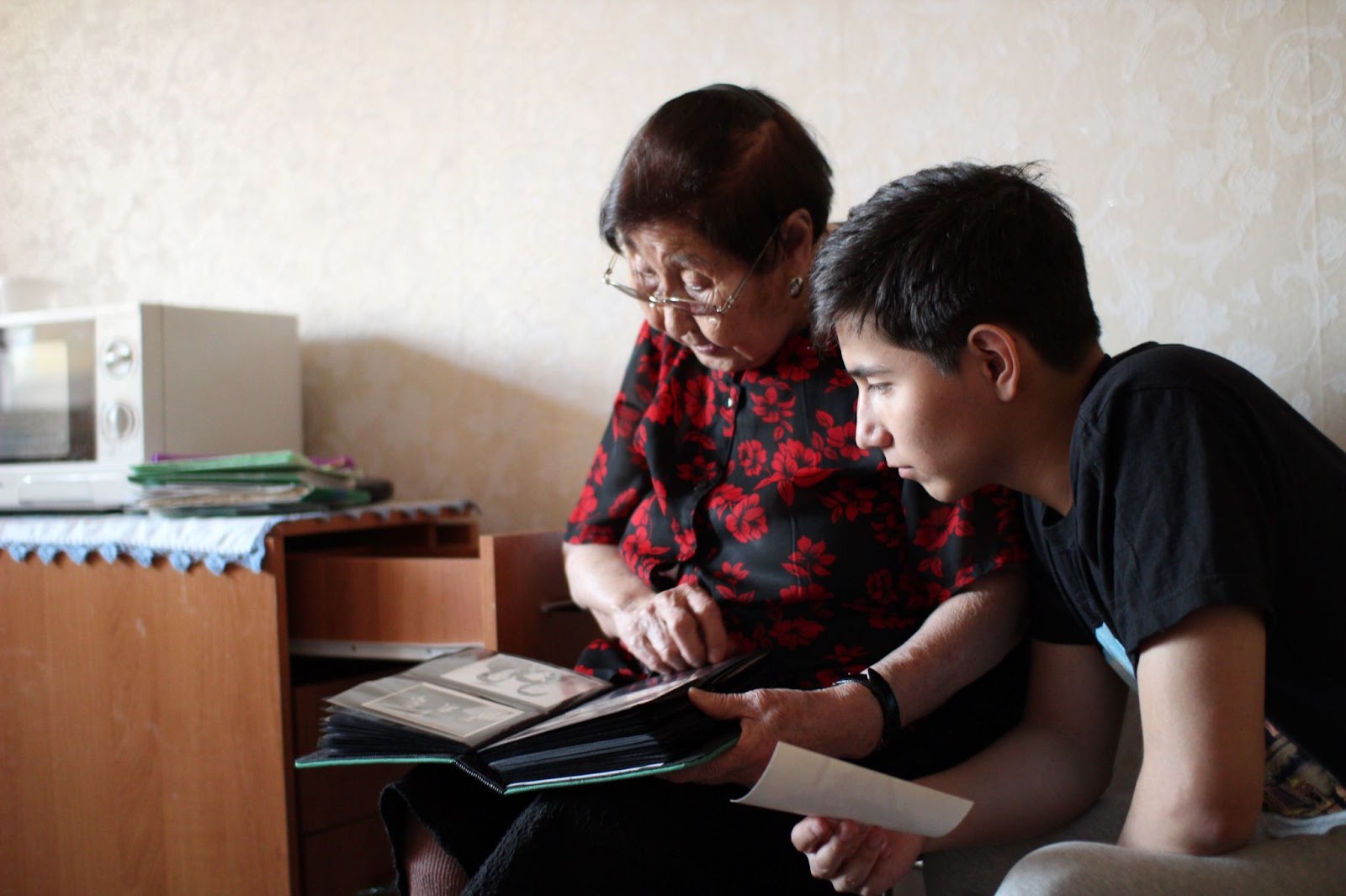 Grandmother-and-grandson-looking-at-album-of-old-photos