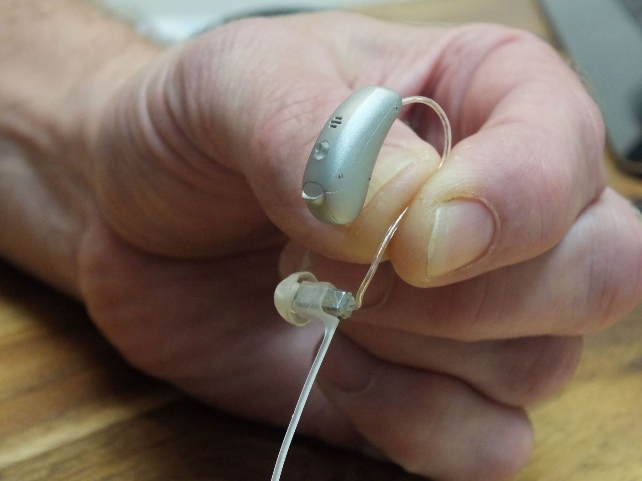 man's-hand-holding-hearing-aid