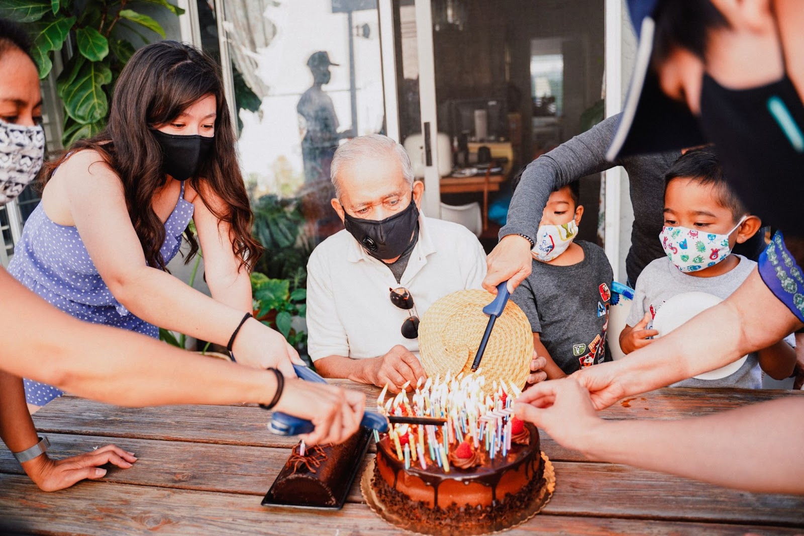 family-celebrating-grandfather's-birthday-with-lots-of-candles-on-cake