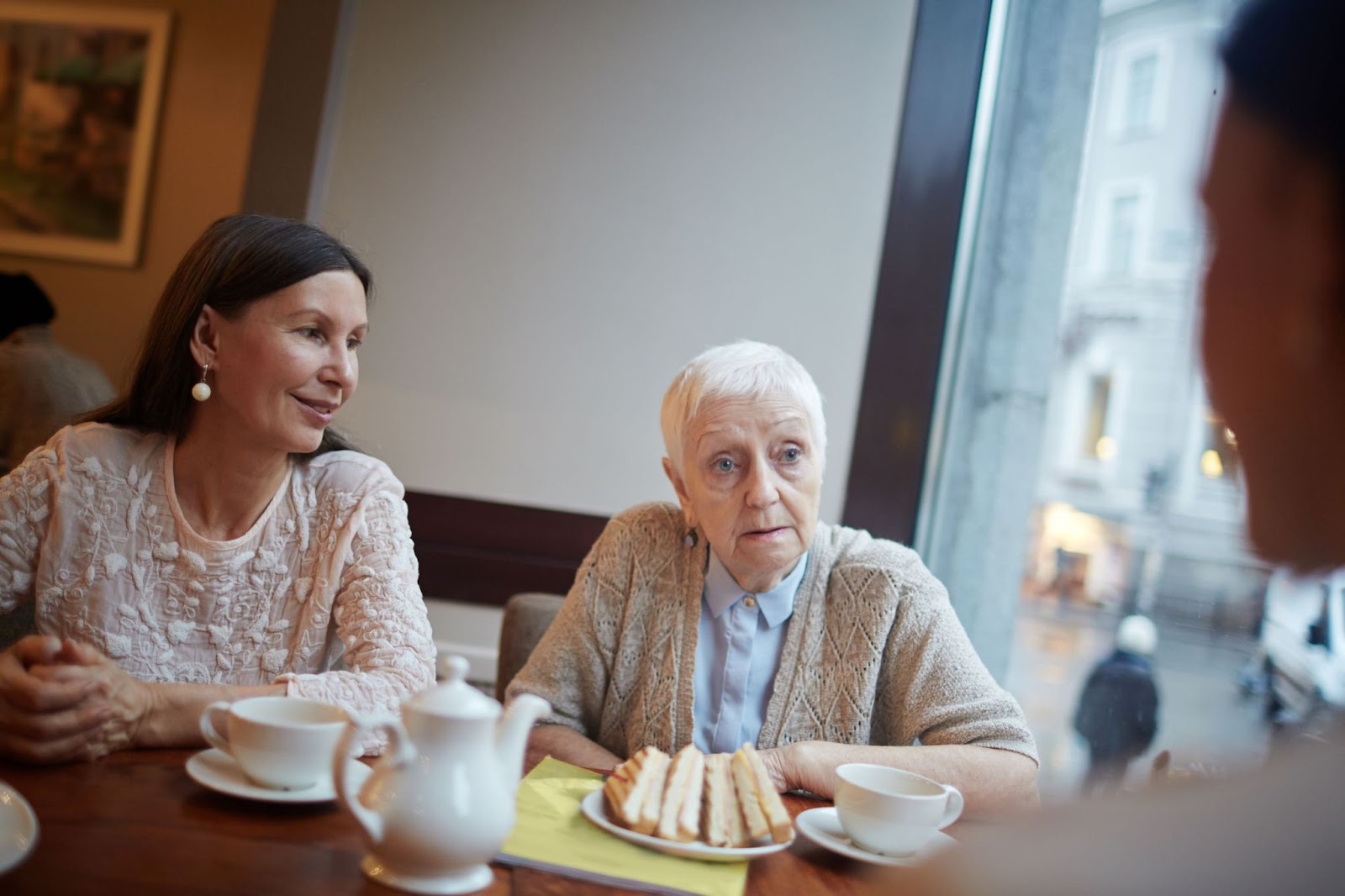 Older-woman-and-younger-woman-having-conversation-in-cafe