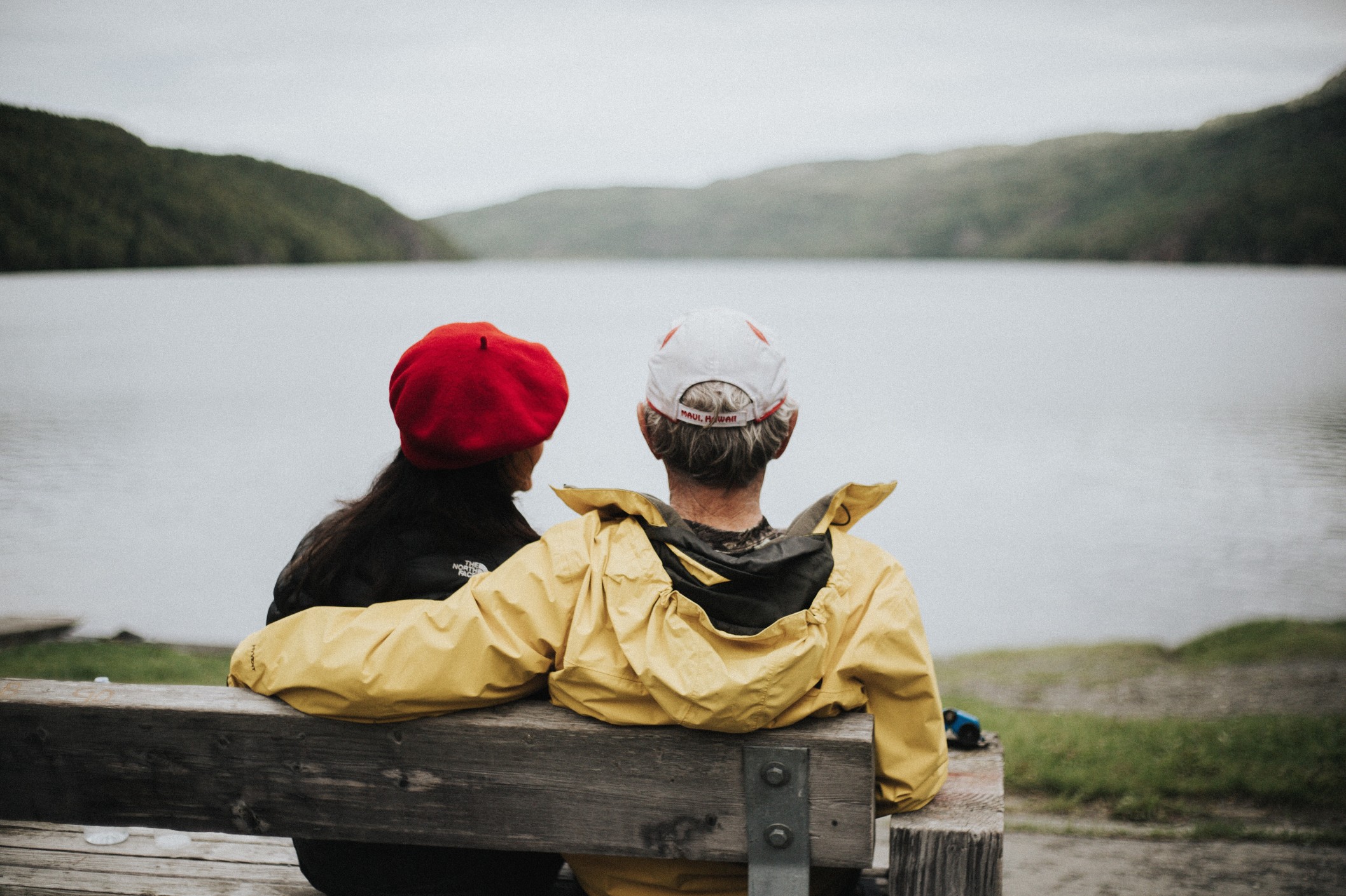 older-couple-sitting-side-by-side-by-lake