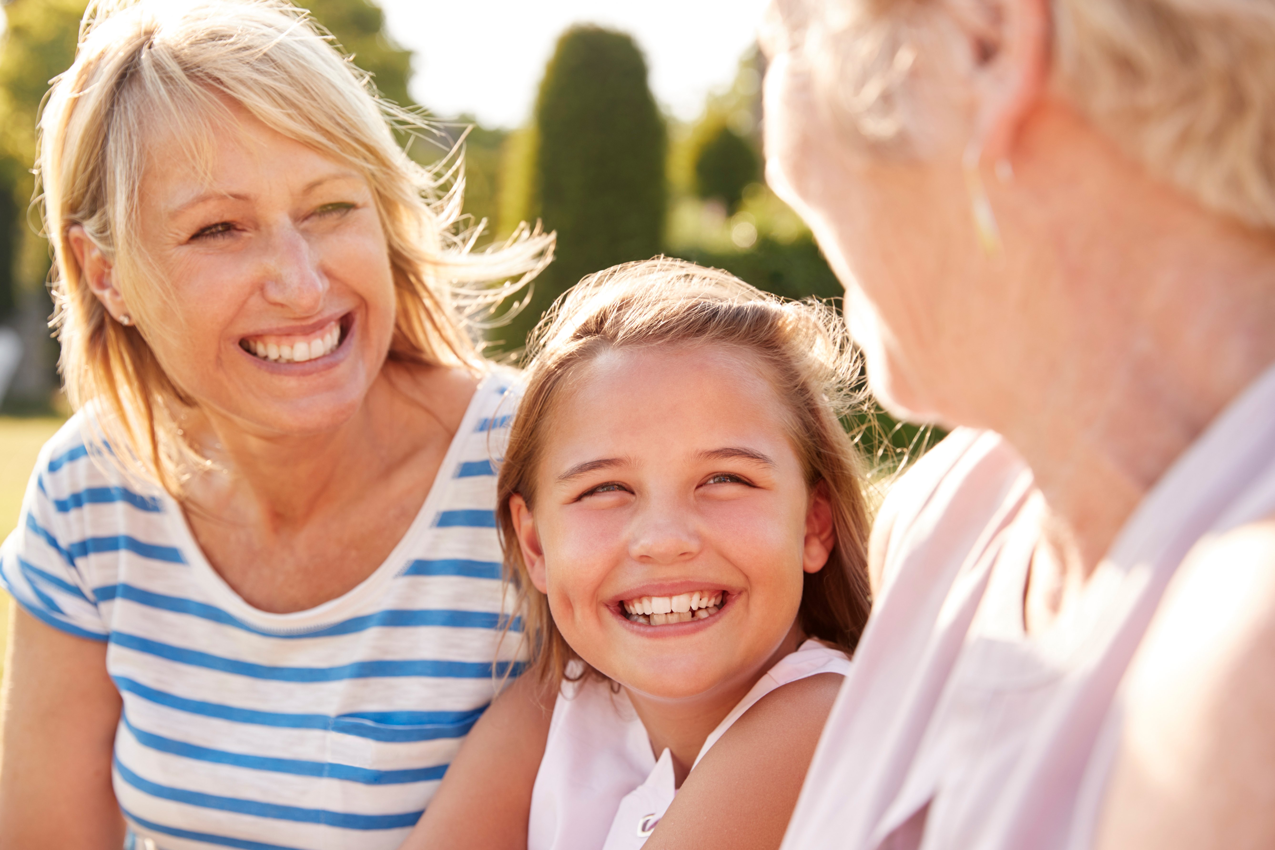 three-female-generations-of-family-sitting-in-a-PL43DHA