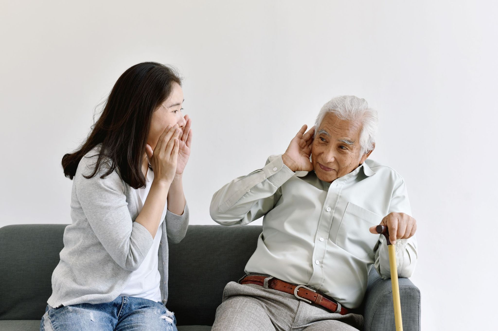 older-man-cupping-hand-over-ear-to-hear-shouting-woman